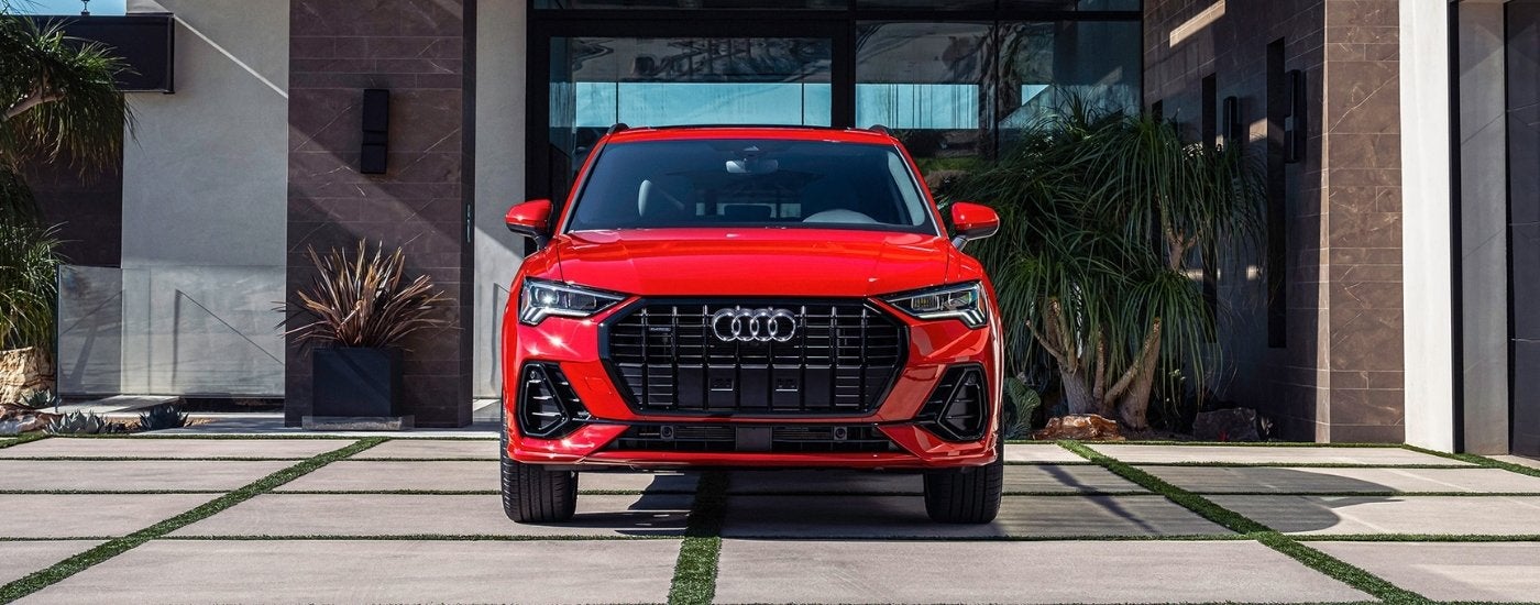 A red 2025 Audi Q3 parked in a driveway after looking at a used Audi for sale.